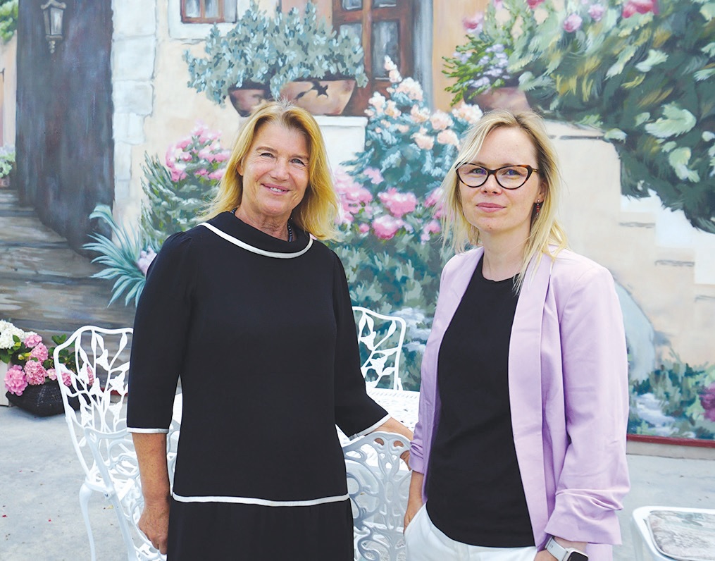 Rimutė Škudienė ir Eglė Škudienė prie freska puoštos dvaro sienos. Šios moterys daugiausia rūpinasi dvaru, jo renginiais./ Rūtos Švedienės nuotr.